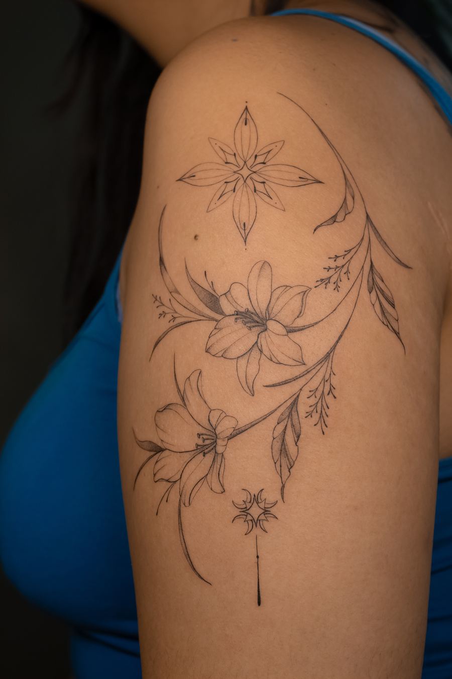 Tattoo of flowers and a celestial star with a crescent moon, shoulder